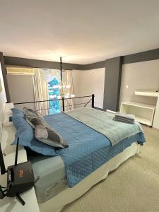 南雅拉瓜Saint Sebastian Flat 716 - Com Hidro! até 3 pessoas, Duplex, no centro的一间卧室配有一张带蓝色床单的床和一扇窗户。