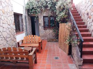 萨尔塔Casa Montaña的两把木凳子坐在带楼梯的庭院