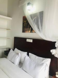 阿洪加拉Ocean Pearl Cottage的一间卧室配有带白色枕头的床