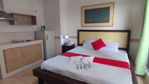 马尼拉Poblacion Bed & Breakfast by SMS Hospitality的卧室配有带红色枕头的大型白色床
