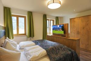 斯陶达奇格达赫Ferienhof Oberhuber的一间卧室配有一张床和一台平面电视