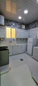 奈季兰إعمار الشرفةللشقق المفروشه的厨房配有白色橱柜和白色家电
