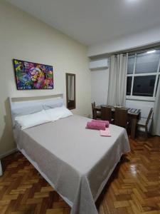 里约热内卢Lindo Loft na Cinelândia的卧室配有一张白色的大床和一张桌子