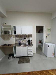 里约热内卢Lindo Loft na Cinelândia的厨房配有白色橱柜和白色冰箱。
