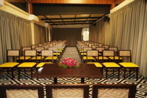 KakkadampoyilMisty Queen By Dimora Hotels的一间设有一排椅子、一张桌子和鲜花的房间