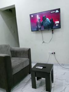 AbeokutaF&B Service Apartment的客厅配有沙发和墙上的电视