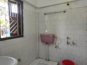 TezuDuda Lodge的一间带粉红色卫生间和盥洗盆的浴室