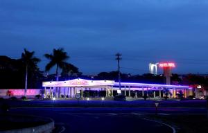 费雷拉港Hotel & Motel Le Baron的夜间有 ⁇ 虹灯标志的建筑