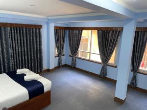 加德满都Andrew Home的一间卧室设有蓝色的墙壁和窗户,配有床