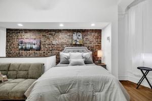 费城Uniquely Designed Metropolitan Apt In Center City的一间卧室设有一张大床和砖墙
