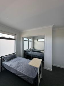 St AlbansComfortable bedroom in a beautiful suburb的一间卧室配有一张床、一张桌子和一面镜子