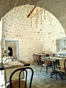 CrispianoHotel Parco delle Querce的一间带桌椅的餐厅以及砖墙