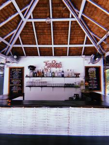 阁帕延岛Tropical Hostel的餐厅设有酒吧,墙上有菜单