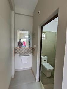 卡尔佩特塔SN Residency的一间带卫生间、水槽和镜子的浴室