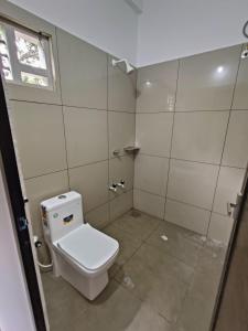 卡尔佩特塔SN Residency的一间带白色卫生间的浴室和窗户。