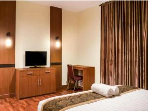 北干巴鲁STEFANI MAKATI HOTEL的酒店客房,配有床和电视