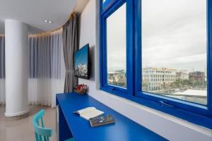 岘港Lucia Beach Hotel的窗户客房内的蓝色书桌