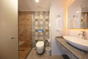 库萨达斯Le Bleu Hotel & Resort Kusadasi的一间带水槽、卫生间和淋浴的浴室