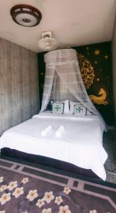 NongkhiawOu River House的卧室配有一张铺有白色床单和鲜花的床。