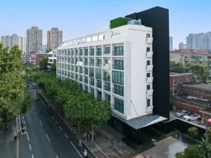 上海上海宓亚酒店(徐家汇交大店)的城市街道上白色的建筑,有绿色的屋顶