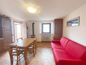 尚波吕克The Snow - Appartamento Panoramico con Balcone的客厅配有红色的沙发和桌子