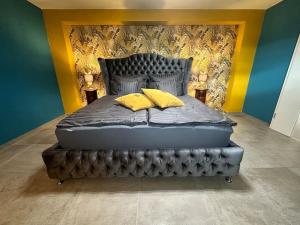 GroßweitzschenPalais -MehrGehtNicht-Maisonette的一张床上有两个黄色枕头的房间