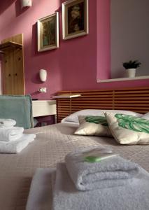 阿伦扎诺塞瑞纳酒店的一间卧室设有粉红色的墙壁和一张带毛巾的床
