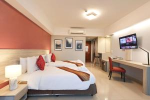 邦帕利暹罗素万那普塔布明酒店的酒店客房配有一张床、一张书桌和一台电视。