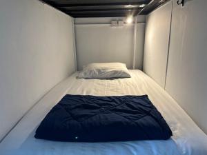 皮皮岛Blue Flow Hostel的小房间的小床,带枕头