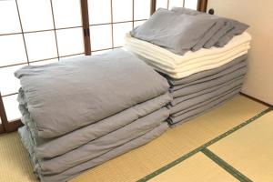 阿苏市Gentou - Vacation STAY 28719v的坐在房间里堆叠的毯子