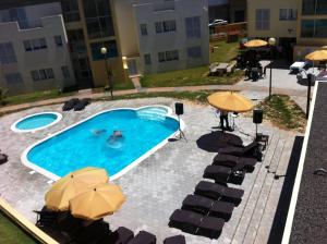 圣港帕拉伊索多拉多公寓的一个带遮阳伞和桌椅的游泳池