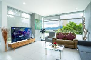 芭东海滩西瑞拉特海景别墅的带沙发和大电视的客厅