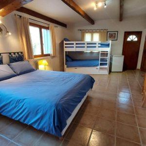 雷居斯le Mas Provençal的一间卧室配有蓝色的床和一张双层床。