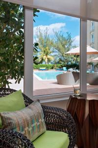 拿骚拿骚市区/贾卡努海滩万怡酒店的一个带藤椅和桌子的庭院和一个游泳池