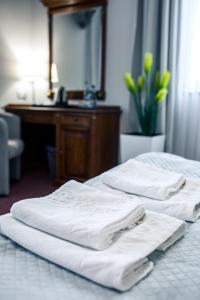 热舒夫Hotel Villa Riviera的两间带白色毛巾的床(位于酒店客房内)