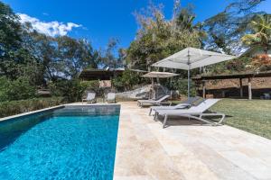 PiraeHorizon Hill Villa的室外游泳池配有2把躺椅和1把遮阳伞