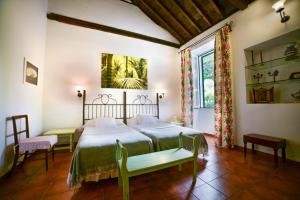 艾尔考迪乔Cortijo San Ignacio的一间卧室配有一张床、两把椅子和一个窗户