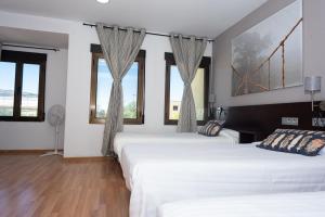 索里亚Hostal Venta de Valcorba的带窗户的客房内的两张床