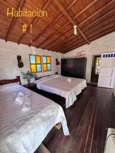 San VicenteEL PARAISO G - FINCA HOTEL LGBT - ADULTS ONLY的铺有木地板的客房内的两张床