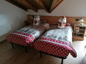 拉瓦罗内Giongo Residence - Appartamenti的两张睡床,床上有泰迪熊