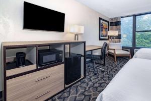 西大西洋城华美达酒店的配有床、书桌和电视的酒店客房