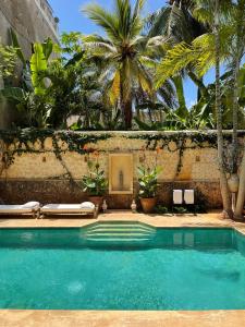 拉穆Ttunu House的棕榈树屋前的游泳池