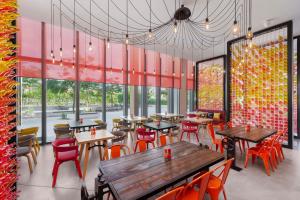 迪拜Hampton by Hilton Dubai Al Seef的餐厅设有桌椅和大窗户。