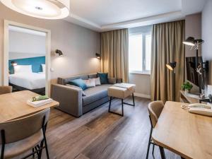 基辅Adagio Kyiv Beresteiska的酒店客房设有一张沙发和一张床