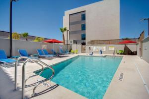 拉斯维加斯Home2 Suites By Hilton Las Vegas North的一座带椅子的游泳池以及一座建筑