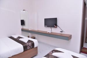 舍地HOTEL D SQUARE .的客房设有两张床和一台墙上的电视