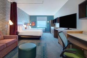 拉斯维加斯Home2 Suites By Hilton Las Vegas North的酒店客房,配有床和电视