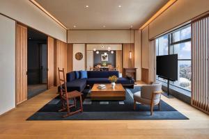上海Artyzen NEW BUND 31 Shanghai Qiantan的客厅配有蓝色的沙发和电视