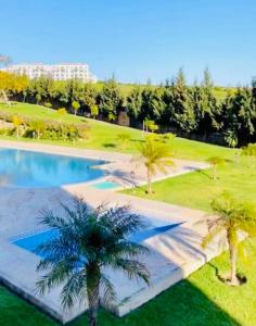 丹吉尔Lujoso apart.vacacional achakar playa& piscina wifi !!的一个带游泳池和棕榈树的度假村