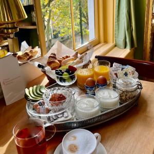 乌得勒支Boutique Hotel Museumkwartier的桌上的早餐食品和饮料托盘